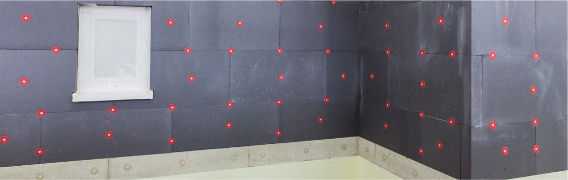 Mur avec des panneaux isolants enduits et des touches de couleur chaudes pour une isolation thermique efficace et la modernisation d&rsquo;un int&eacute;rieur.
