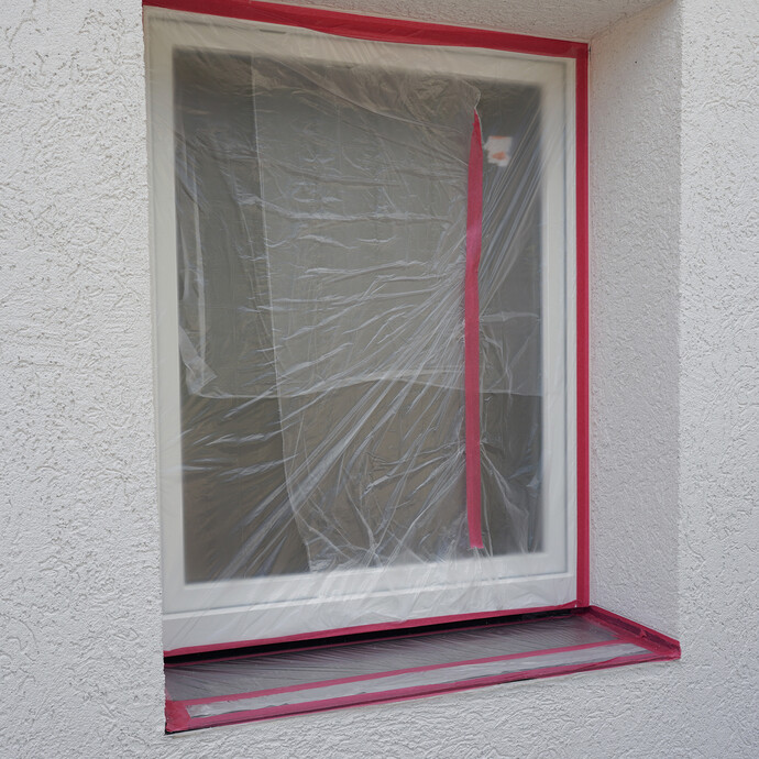 Mit Folie und Klebeband abgedecktes Fenster.