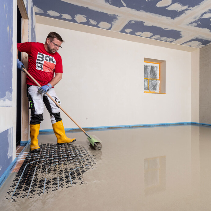 Heimwerker entlüftet die eingebaute Ausgleichsmasse mit Hilfe einer Stachelwalze (auch Igelwalze genannt).
