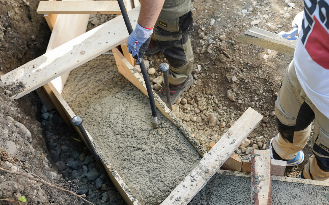 Sobald ausreichend Baumit Trockenbeton in der Schalung ist, wird der Frischm&ouml;rtel f&uuml;r das Fundament mit einer R&uuml;ttelflasche bzw. einem Innenr&uuml;ttler verdichtet.