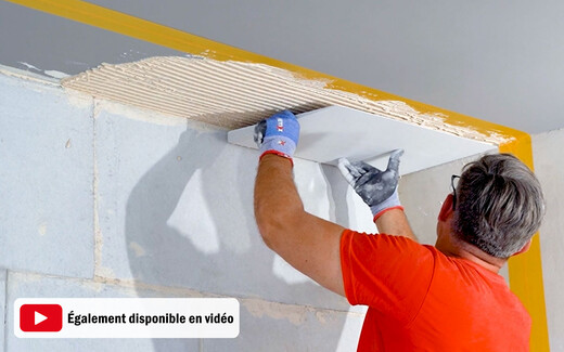 Anleitung Teaser - Laibunsplatte und Anschlusskeil im Antischimmel-System kleben. Person klebt den Kalziumsilikatplatte Anschlusskeil an die Decke. Die Anleitung ist auch als Video verfügbar.