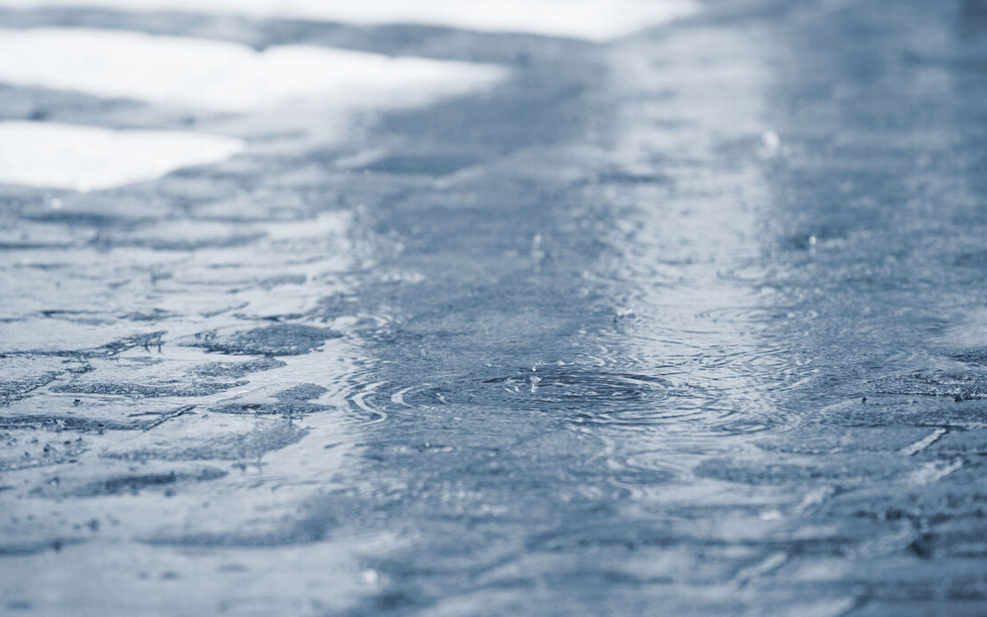 Es regnet in Str&ouml;men auf Pflastersteine.