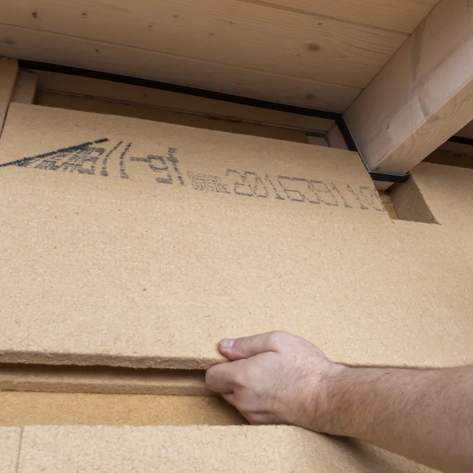 Hand montiert Holzfaser-Dämmplatte für nachhaltige Wanddämmung, ideal für Heimwerkerprojekte mit Baumit-Produkten.