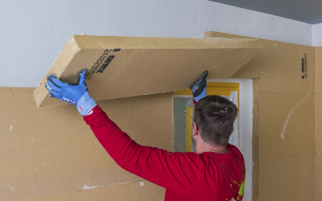 Die Holzfaserd&auml;mmplatte Thermoroom wird an die Wand geklebt.