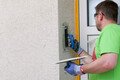 Bricoleur, crépissez et structurez l'embrasure avec l'enduit fouetté de Munich.