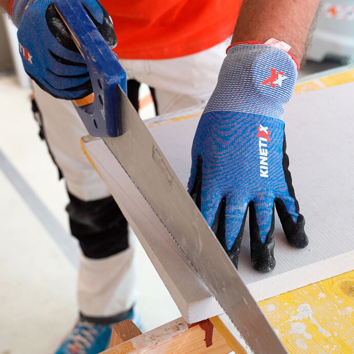 Person sägt den Kalziumsilikatplatte Anschlusskeil mit einer Handsäge zu. 