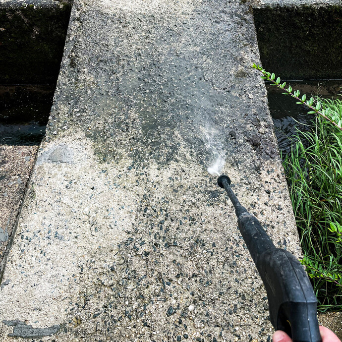 Betonuntergrund wird mit einem Hochdruckreiniger gründlich gereinigt, um Schmutz und lose Bestandteile vor der Weiterverarbeitung zu entfernen.