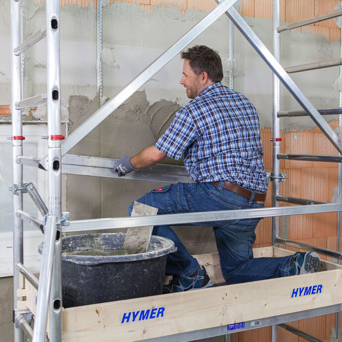 Der frische Kalkzementputz wird beim Verputzen der Wand mit einer Kartätsche eben abgezogen.