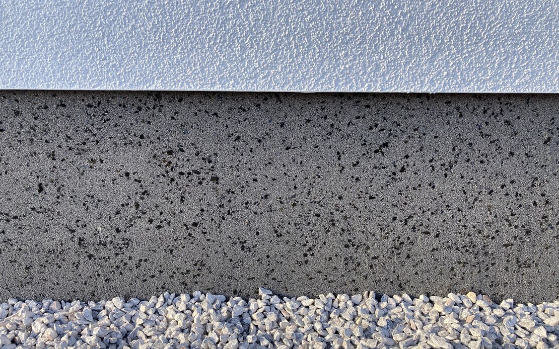 Der Sockel ist mit Sockelputz verputzt in Kombination mit einem wei&szlig;en, feinen Strukturputz.