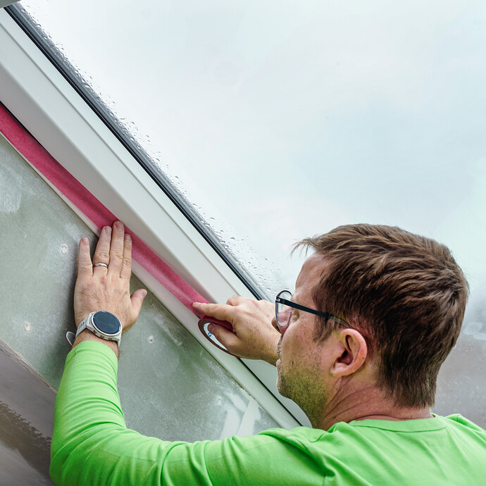 Une fenêtre est recouverte d'un ruban de masquage.