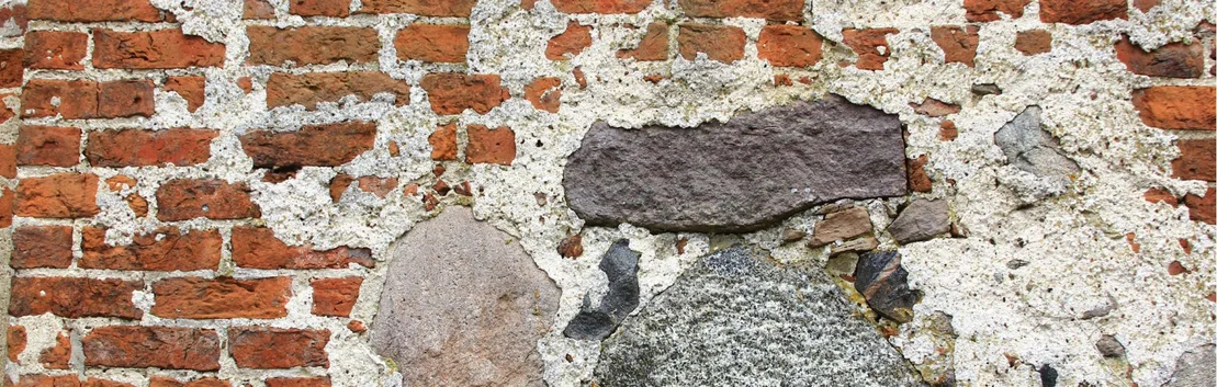 Partie d&rsquo;un ancien mur en briques pr&eacute;sentant des restes visibles d&rsquo;enduit et de mortier, dans le cadre d&rsquo;un projet de r&eacute;novation.