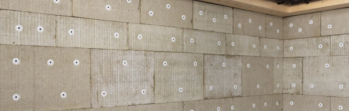 Wand mit befestigten Dämmplatten zur Wärmedämmung, bereit für Verputzarbeiten. Ideal für Heimwerkerprojekte innen.