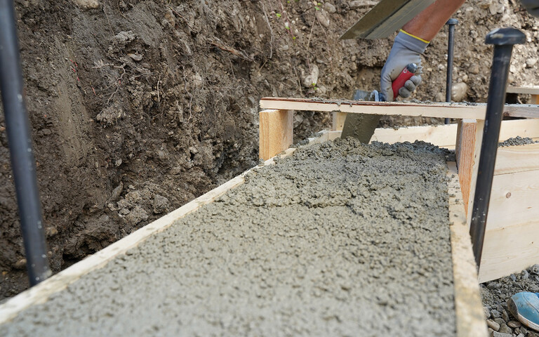 Für das Streifenfundament ist die Oberfläche des frischen Betons in der Schalung eben abgezogen.