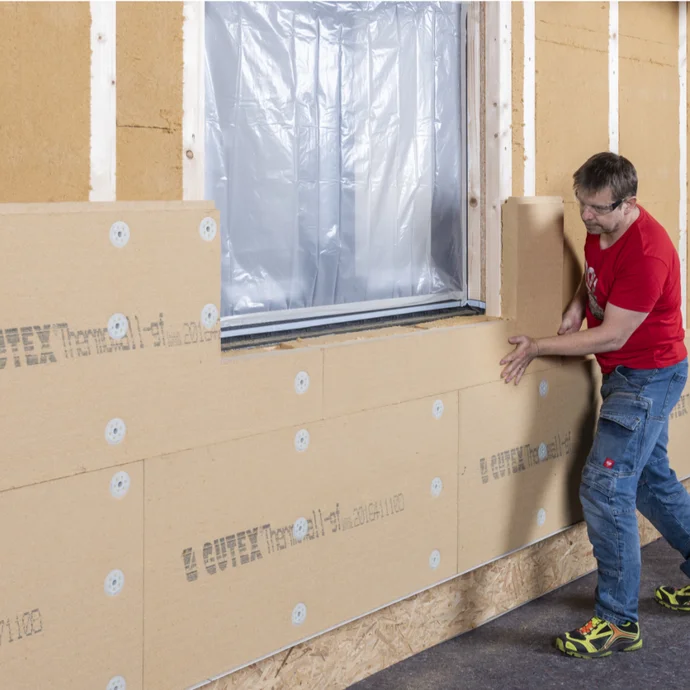 Mann montiert Dämmplatten an Fassade, Schritt-für-Schritt-Anleitung zur Wärmedämmung mit Baumit-Produkten für Heimwerker.