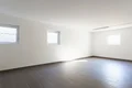 Pièce lumineuse aux murs blancs, dotée de deux fenêtres et d’un sol carrelé foncé, idéale pour trouver des idées de projets de rénovation.