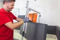 Un bricoleur découpe un panneau isolant à l’aide d’outils de précision – idéal pour une isolation thermique efficace dans le cadre de projets de bricolage.