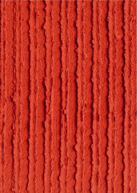 Enduit structuré rouge à rainures verticales, idéal pour l’aménagement décoratif des façades et les projets de rénovation en intérieur et en extérieur.