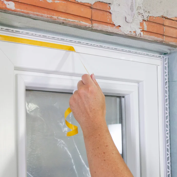 Retirer le papier de protection jaune sur la lèvre en plastique au niveau de la baguette de finition.