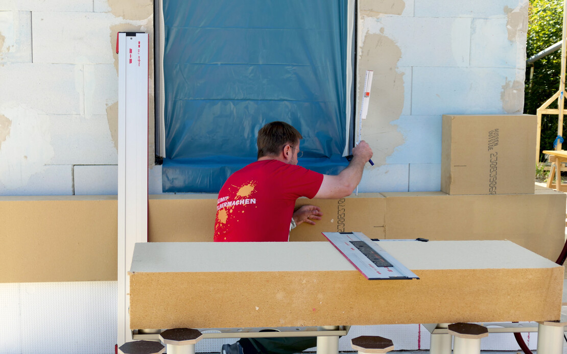 Die Holzfaserd&auml;mmplatte GUTEX Thermowall L wird als WDVS an die Fassade geklebt.