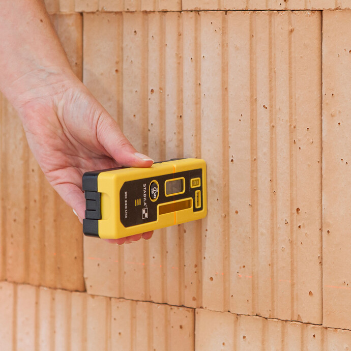 Contrôler les irrégularités d'un mur avec un laser de construction et un récepteur laser : Cela permet de détecter des écarts allant jusqu'à 20 mètres.