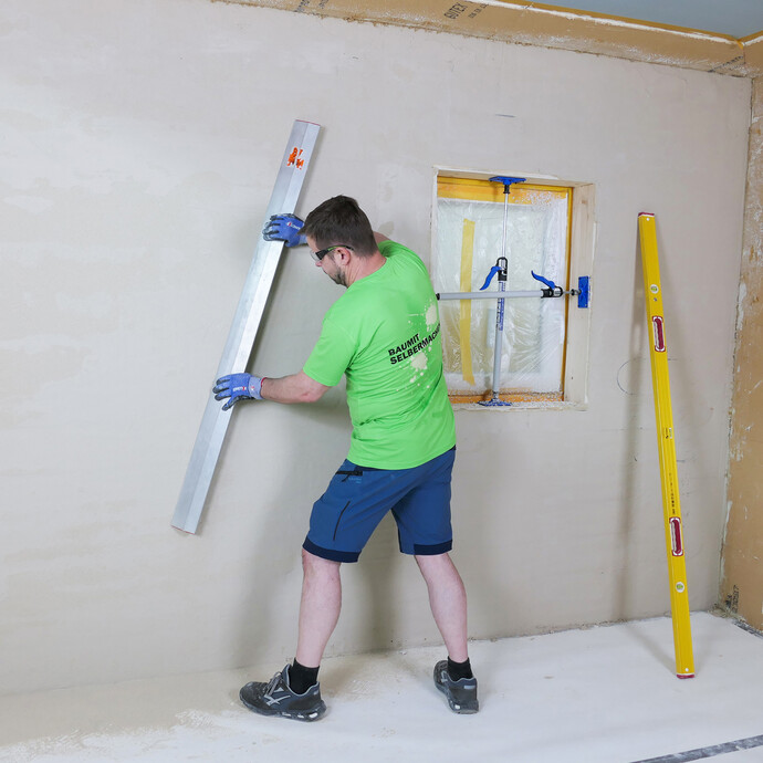 Der Putzfläche wird mit einer Trapezleiste begradigt.
