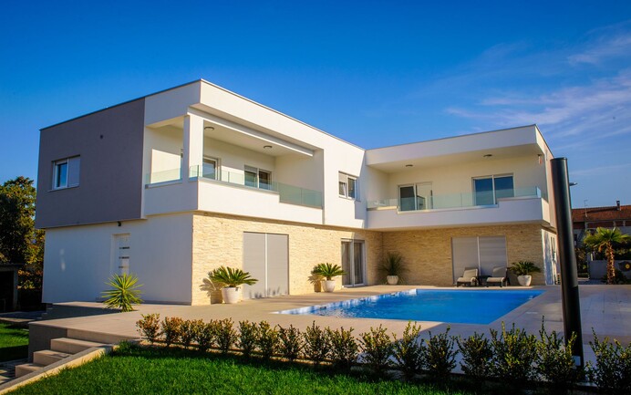 Maison individuelle avec enduit crème et pierres d'ardoise 