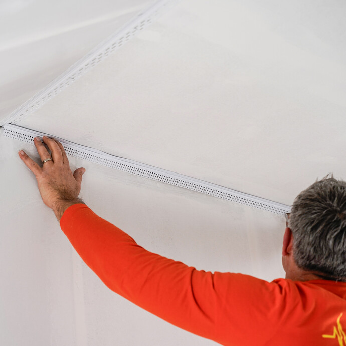 Le profilé de raccordement découpé est introduit dans l'espace prévu.