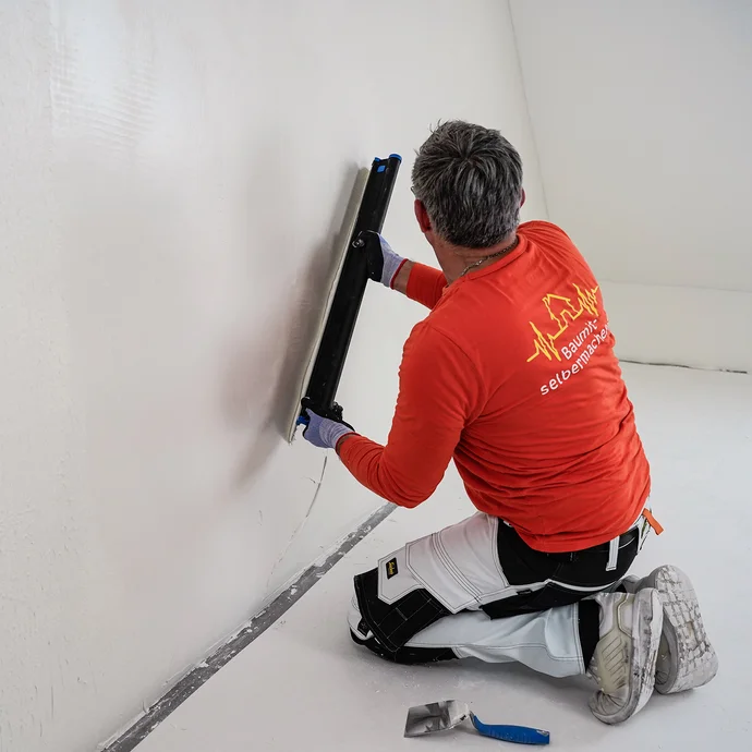 Le mur est nivelé avec la spatule de surface Storch Flexogrip.