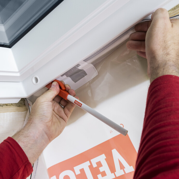 Velux Dampfsperrschürze mit mitgeliefertem Werkzeug in den Fensterrahmen eindrücken
