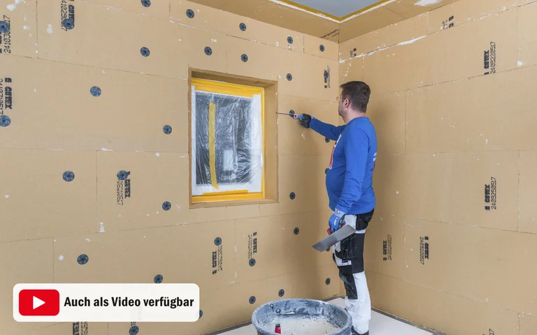 Heimwerker trägt Spachtelmasse auf Trockenbauwand um ein Fenster auf; Schritt-für-Schritt-Anleitung für DIY-Projekte.