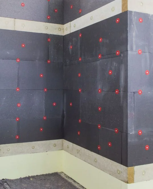 Panneaux isolants fixés sur la façade d’un bâtiment – Étape par étape vers une isolation optimale avec Baumit.