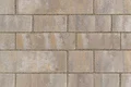 Mauer aus rechteckigen, beige- und graufarbigen Betonsteinen, gleichmäßig verfugt für stabile Wandkonstruktionen.