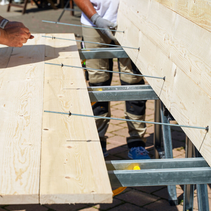 In die vorbereiteten Bohrlöcher werden 6-mm-Gewindestangen eingesetzt. Diese verbinden die beiden Schaltafeln im unteren Bereich zu einem Schalungselement.  u kannst damit unter anderem die Breite des Streifenfundaments einstellen.