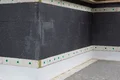 Isolation de façade à l’aide de panneaux isolants foncés et de chevilles de fixation pour améliorer l’efficacité énergétique et isoler les murs.