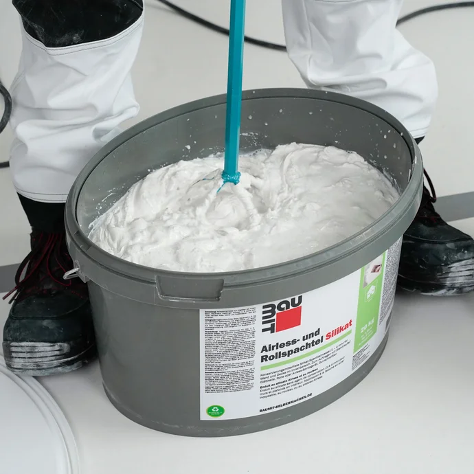 Le mastic silicate en rouleau est mélangé à l'aide d'un agitateur électrique.