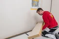Die Holzfaser-Dämmplatte Thermoroom wird an die Wand geklebt.