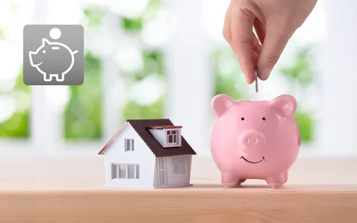 Miniaturhaus und Sparschwein symbolisieren Einsparungen bei Bauprojekten mit Baumit.