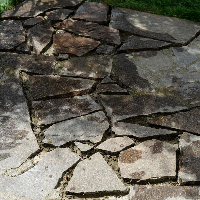 Reparierte Terrasse mit neu verklebten Natursteinplatten – Fläche und Steinkleber muss trocknen. 