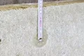 Isolation à l'aide de panneaux isolants fixés au mur et vérification à l'aide d'un mètre ruban.