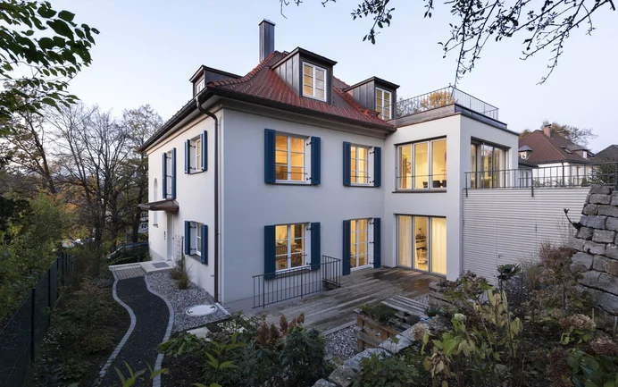 Modernisierter Altbau mit neuem Fassadenputz und energieeffizienten Fenstern, ideal für Renovierungsinspirationen.
