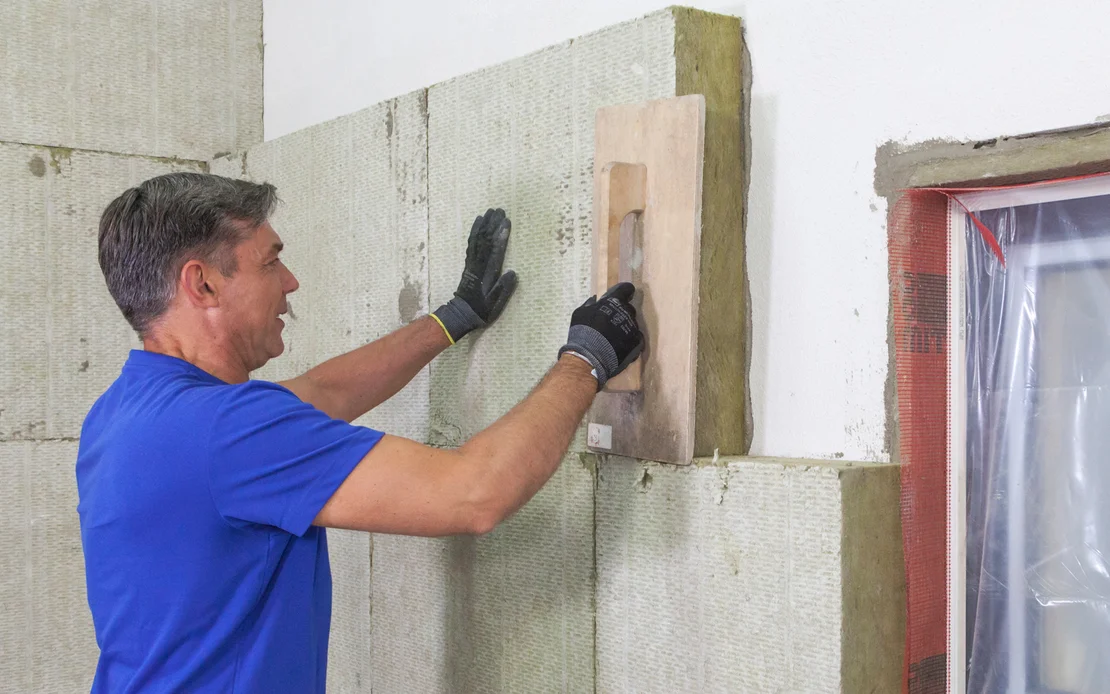 Heimwerker isoliert eine Wand mit D&auml;mmplatten; Schritt-f&uuml;r-Schritt-Anleitung f&uuml;r eine effiziente W&auml;rmed&auml;mmung.