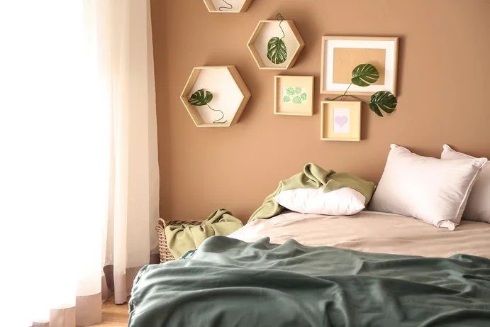 Une chambre à coucher chaleureuse, avec une décoration murale moderne et des tons naturels, source d’inspiration pour des idées d’aménagement créatives.