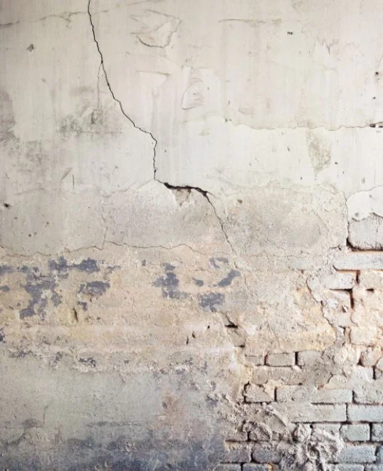 Mur fissuré et écaillé avec des briques apparentes : identifier les besoins de rénovation et effectuer des réparations efficaces.