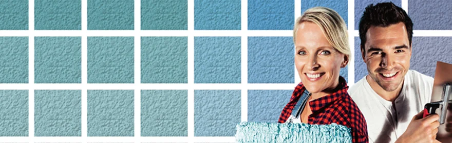 Un homme et une femme devant un mur avec des &eacute;chantillons de peinture, tenant une palette de couleurs et un pinceau, symbolisant la r&eacute;novation int&eacute;rieure en bricolage avec les produits Baumit.
