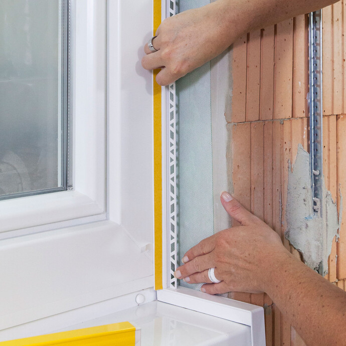 La baguette de finition est placée et collée sur l'appui de fenêtre.
