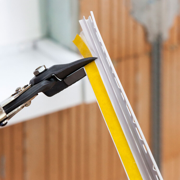 Photo de détail : Découper la baguette d'appoint pour crépi avec des ciseaux à onglet.