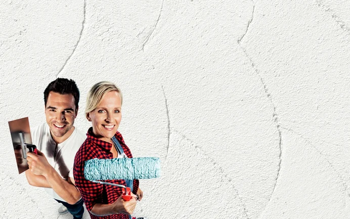 Heimwerker tragen frischen Putz mit Rolle und Kelle auf; Wand-Renovierung leicht gemacht mit Baumit-Produkten.