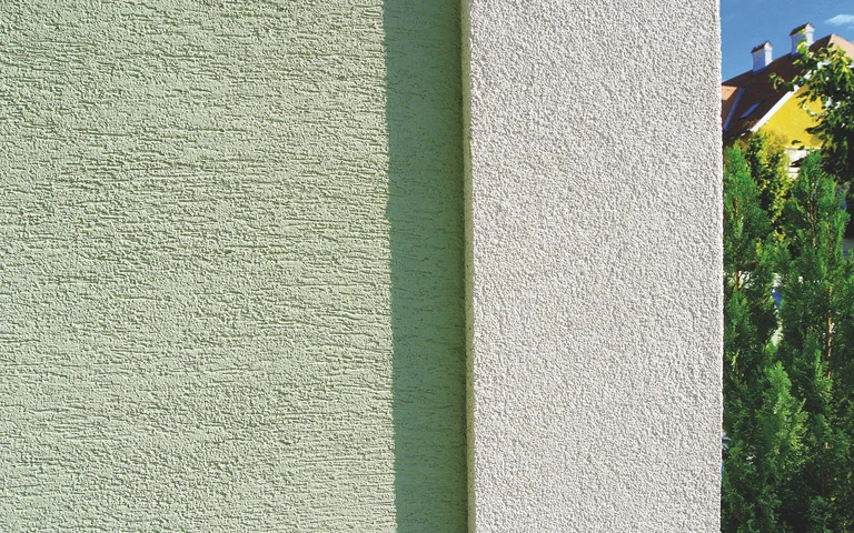 Fassadenvergleich: Links strukturierter, grüner Putz; Rechts glatter, weißer Putz für moderne Hausgestaltung.
